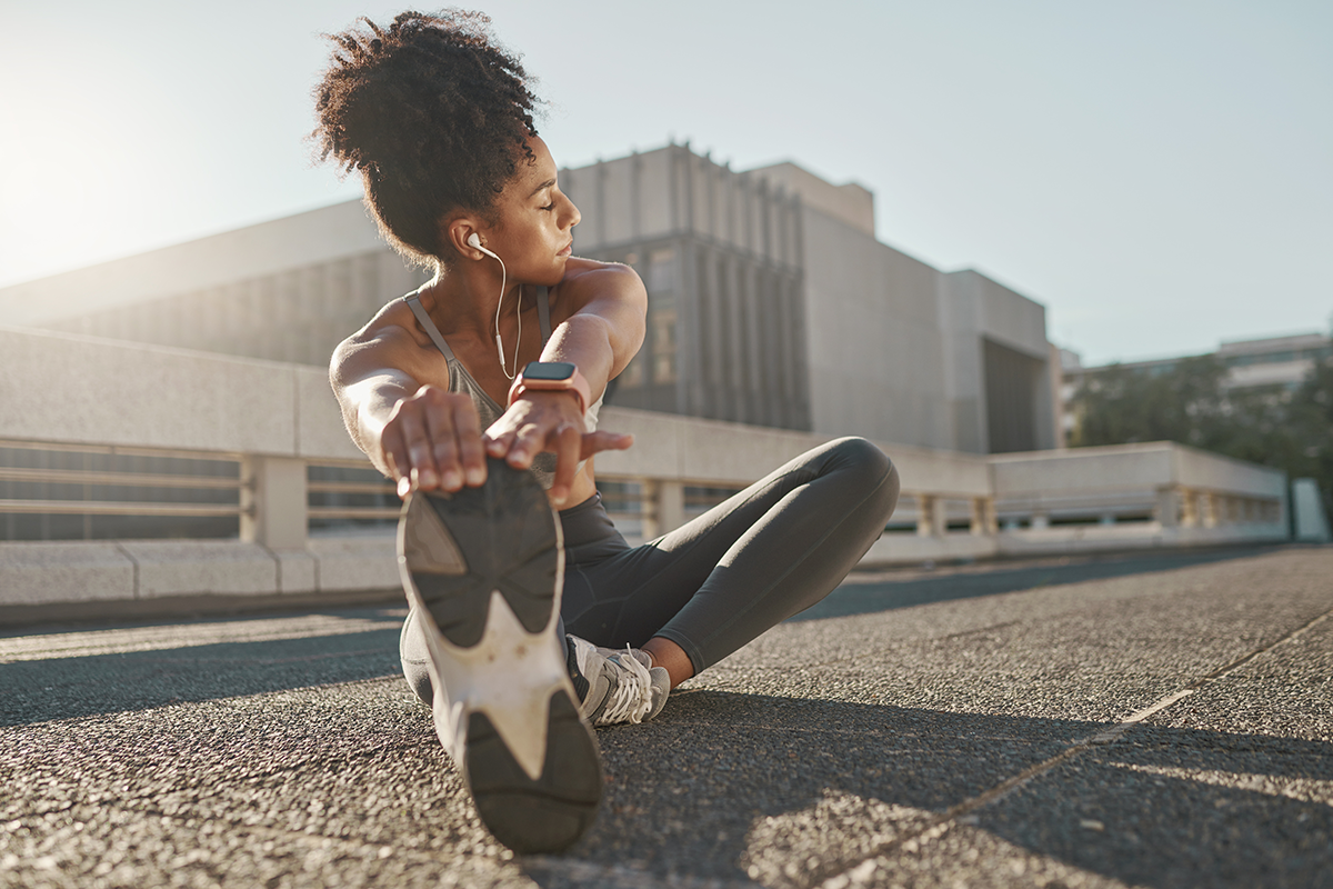 woman stretching her legs in the street before running woman stretching her legs in the street before running