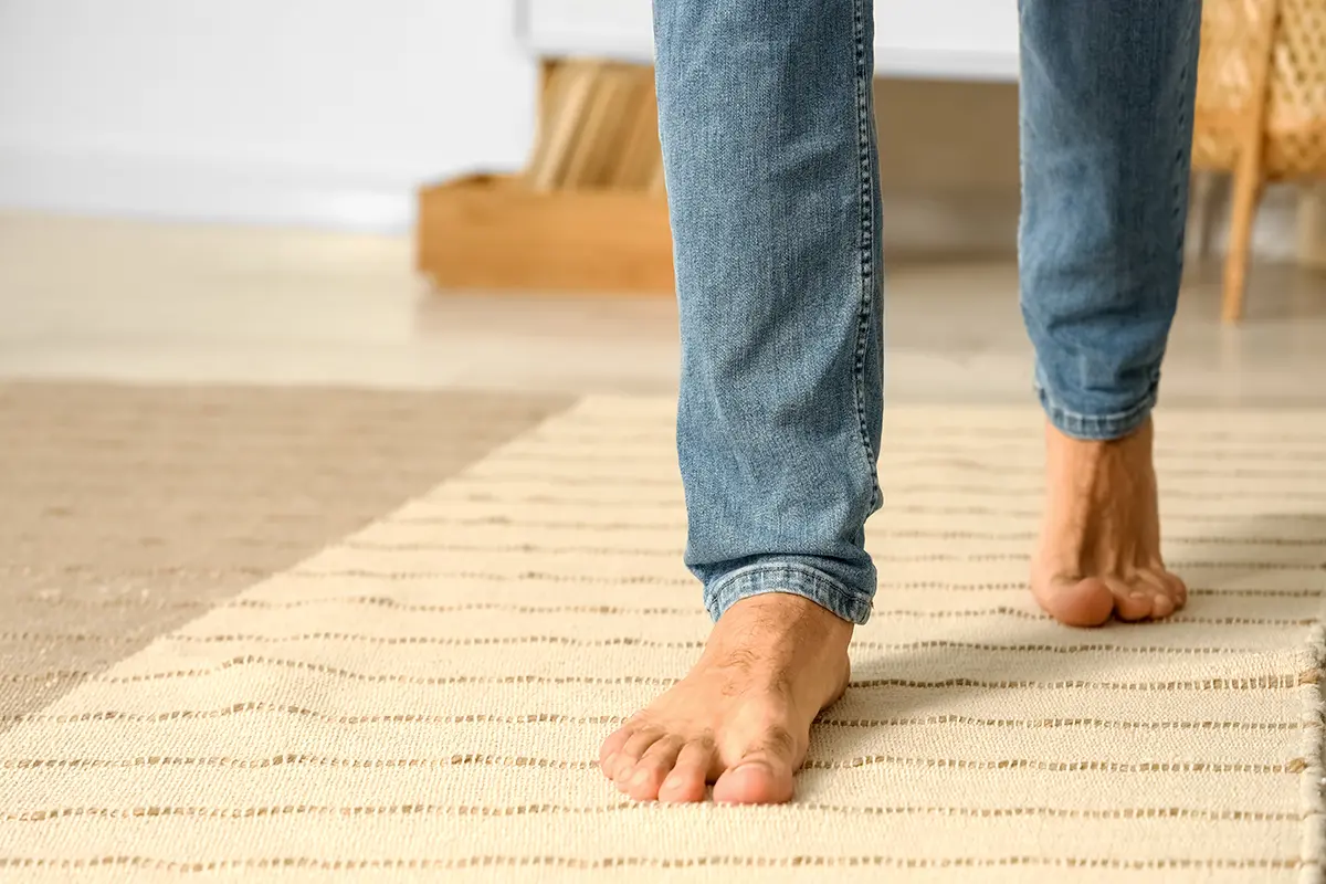 bare feet of young man walking at home bare feet of young man walking at home