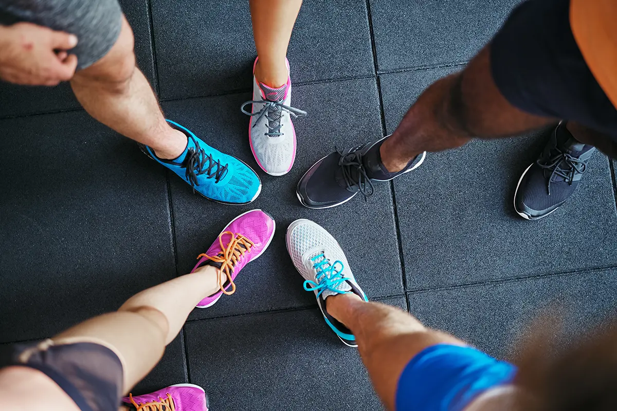 diverse people wearing running shoes standing in a gym diverse people wearing running shoes standing in a gym