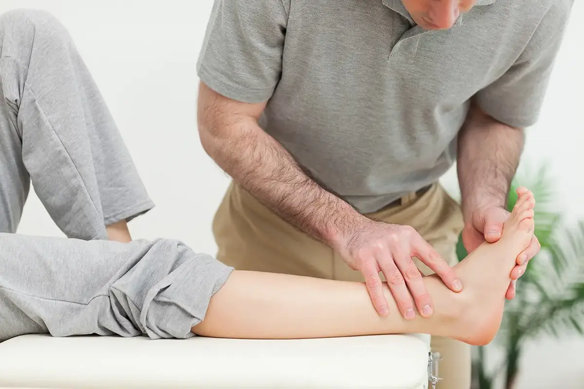 doctor examining the foot of a woman doctor examining the foot of a woman